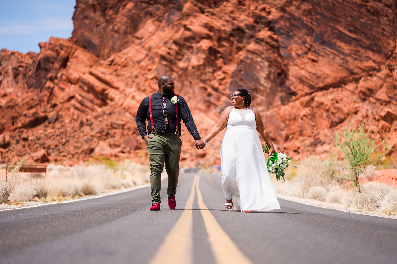 A bride and groom walking within Valley of Fire State Park in Las Vegas after their elopement ceremony