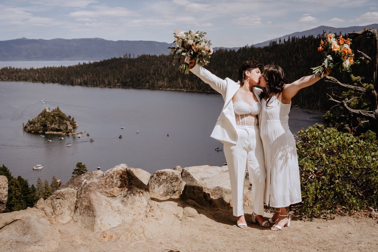 Two brides share a kiss after their lakeside elopement